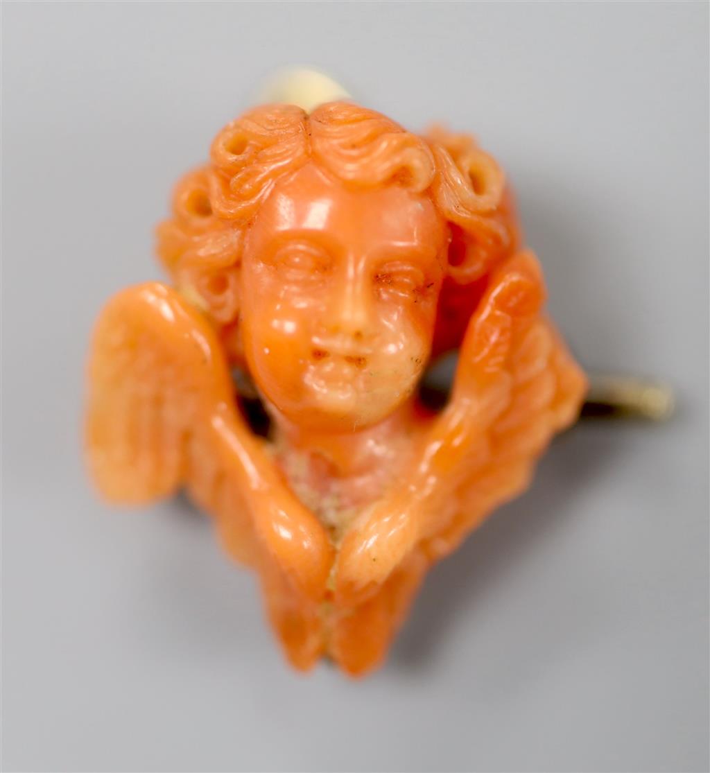 A 19th century yellow metal mounted coral brooch, carved as the bust of a cherub, 22mm, gross 5.3 grams.
